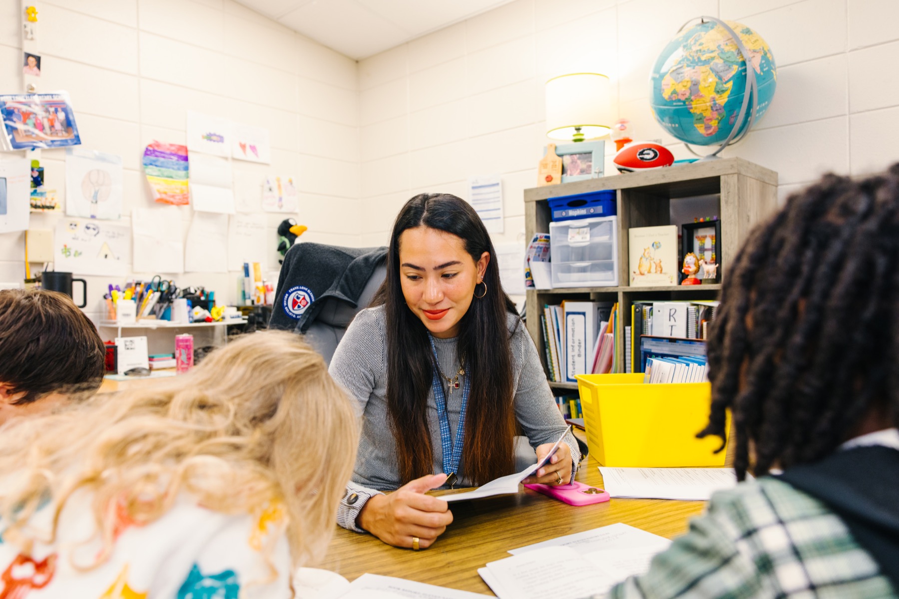 A teacher supporting students together at a classroom table