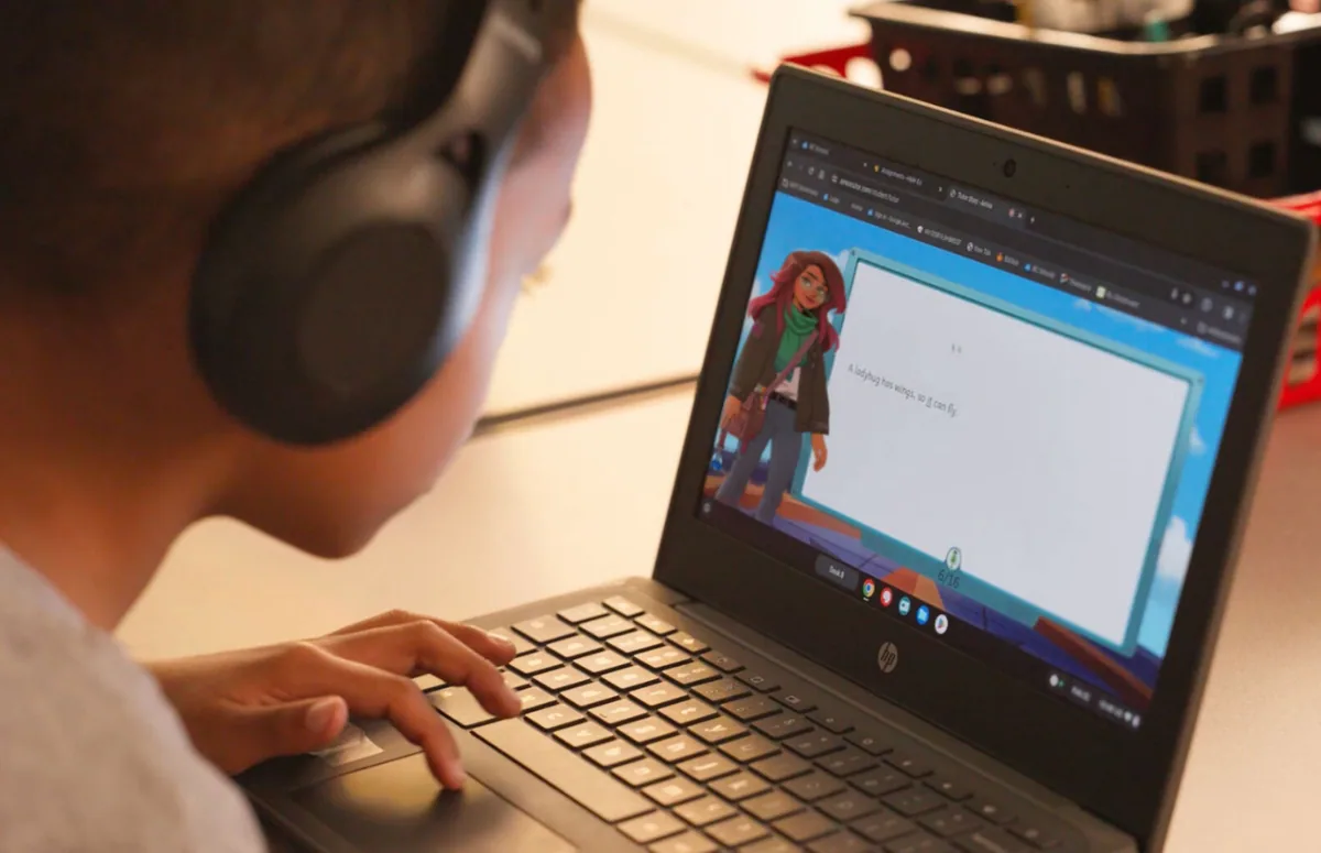 Student reading with Amira on a laptop